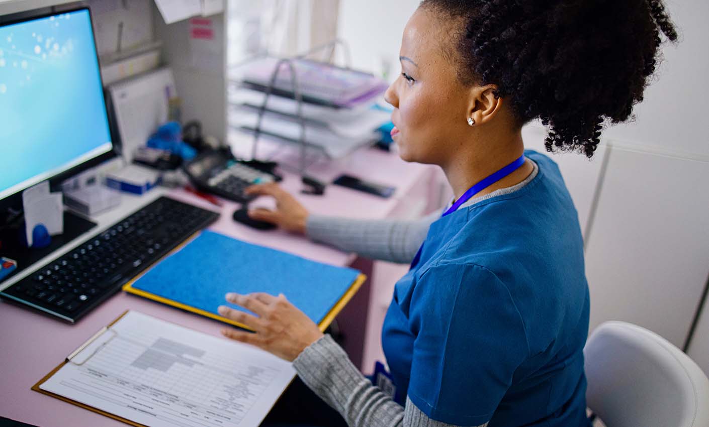 Doctor completing admin at computer