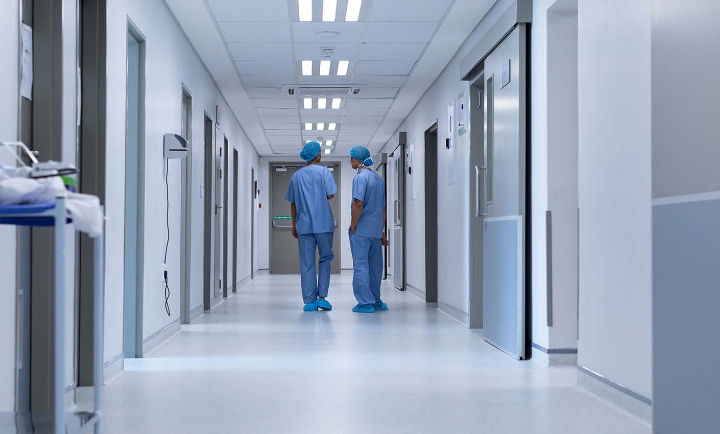 Hospital corridor with two people in scrubs