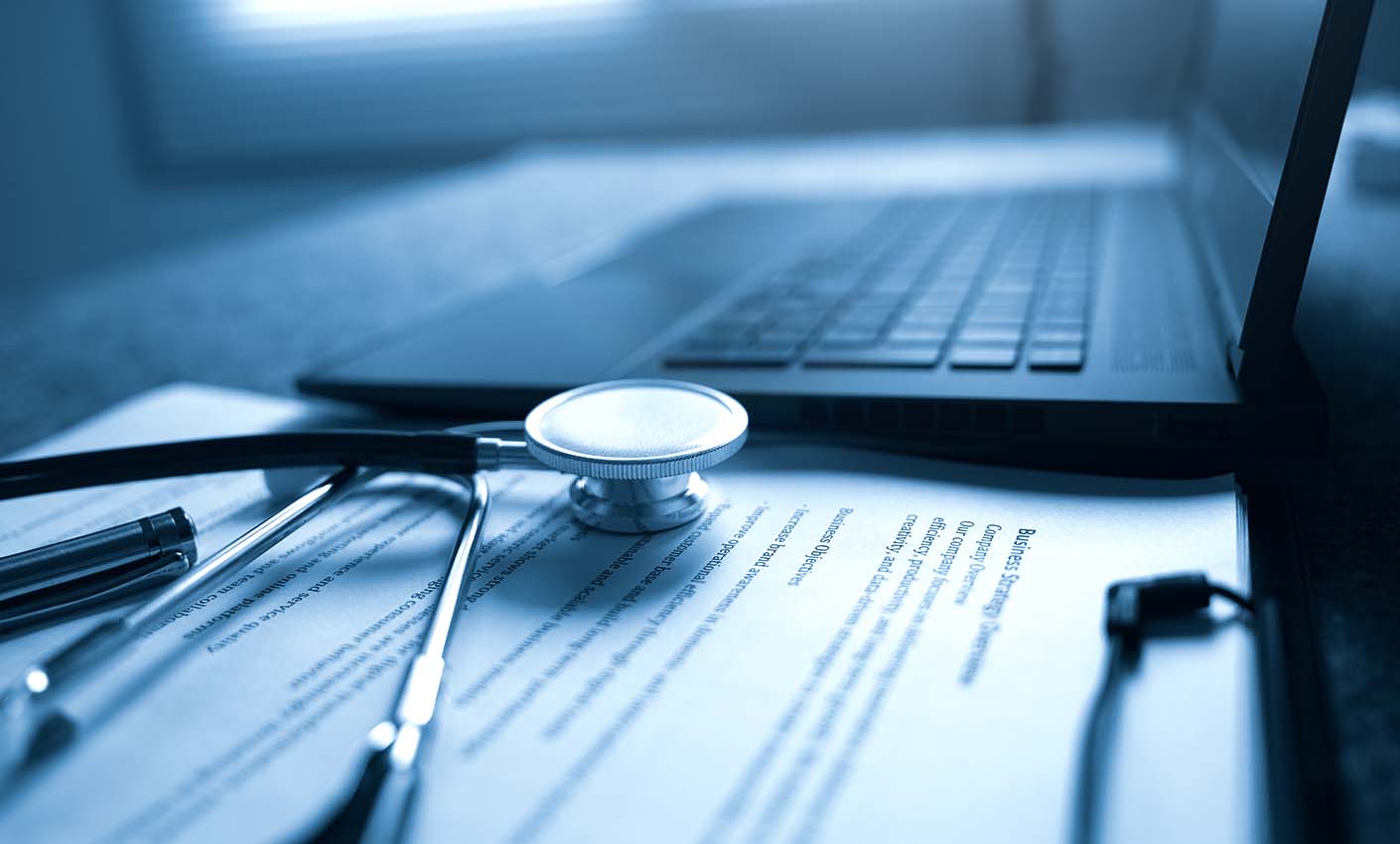 Doctor's desk with laptop and notes